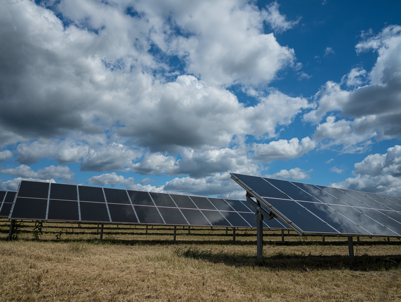 Solar panels on a red-tiled roof against a blue sky