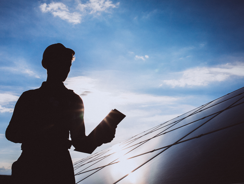An installer fitting a solar panel to a roof